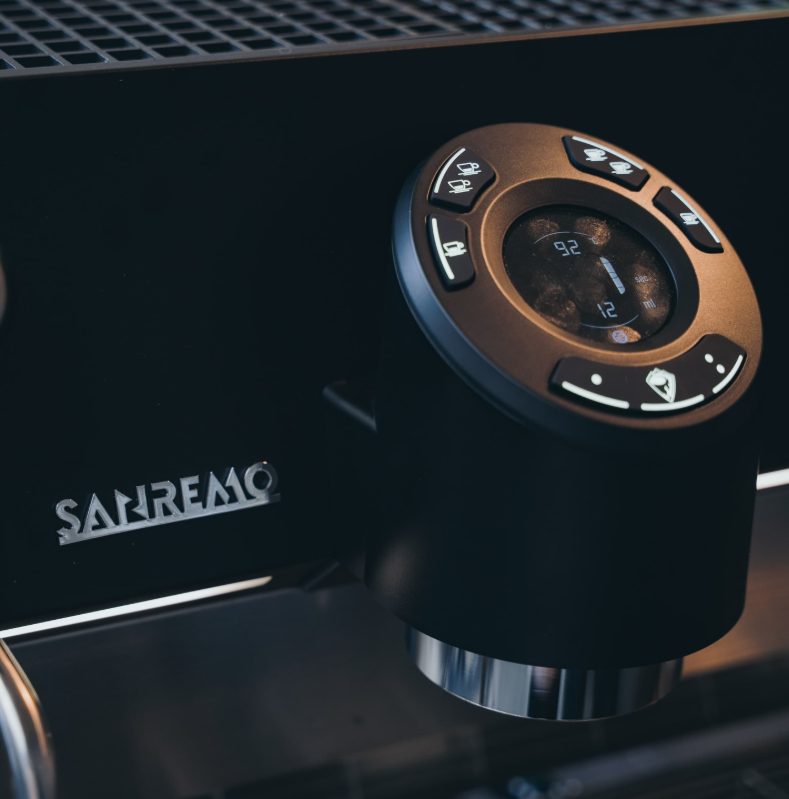 Close-up grinder dan mesin espresso Sanremo berwarna hitam
